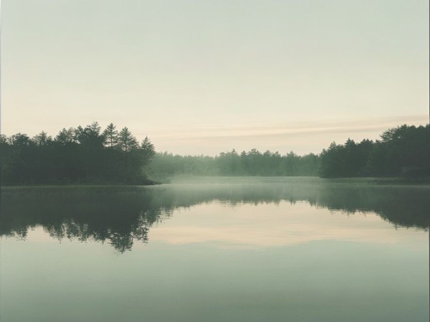 Rolig innsjø eller bekk med naturlig refleksjon og omgivende steiner